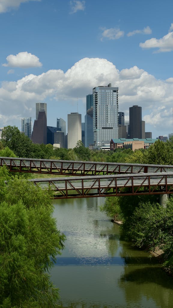 Beautiful view of Houston skyline with bridge over tranquil river.